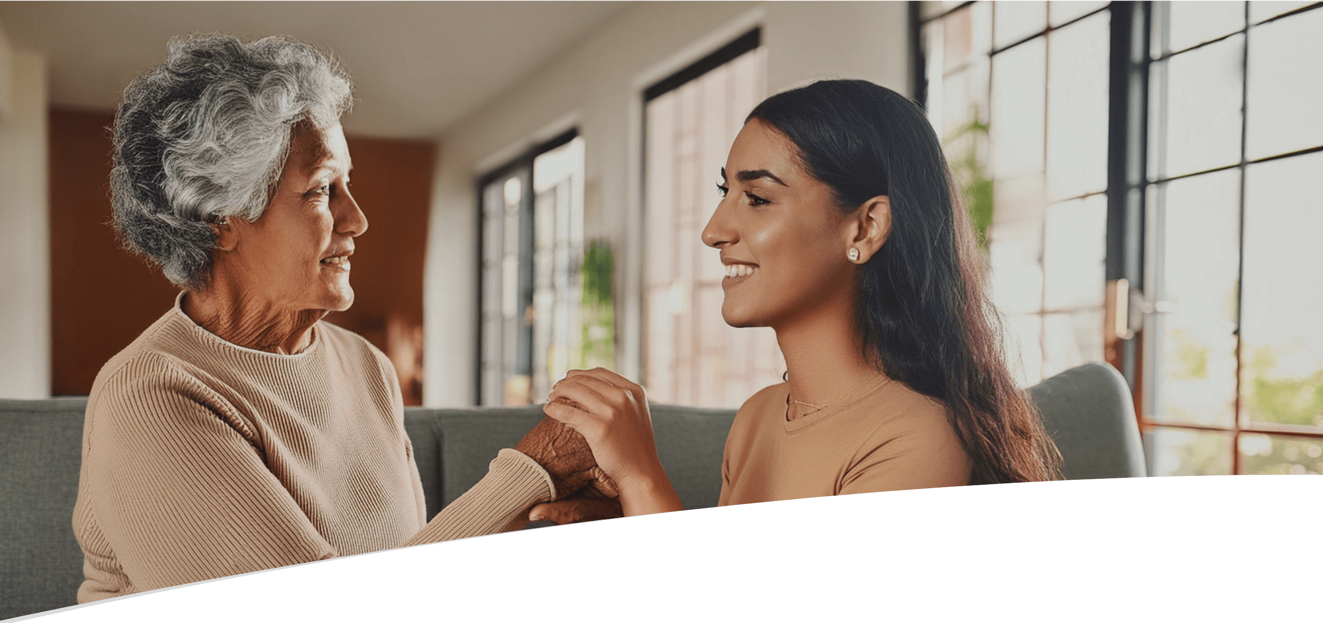 Junge Frau hält die Hände einer älteren Frau